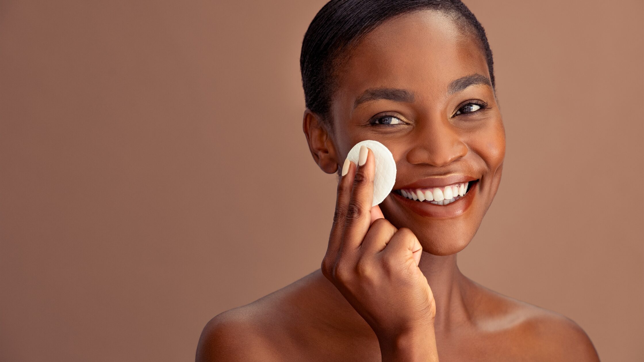 Woman applying minimal skincare routine with gentle cleanser and moisturizer, demonstrating a simple dermatologist-recommended approach to healthy skin.