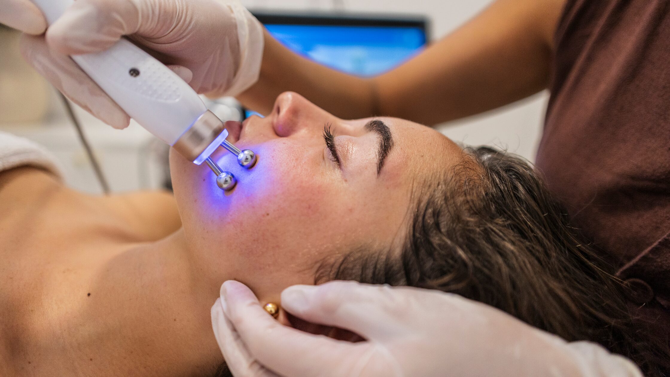 Woman receiving cosmetic injectable treatment in a dermatology office during summer, highlighting safe warm-weather aesthetic procedures.